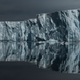 The front of Thwaites Glacier, including its reflection in the surrounding ocean.